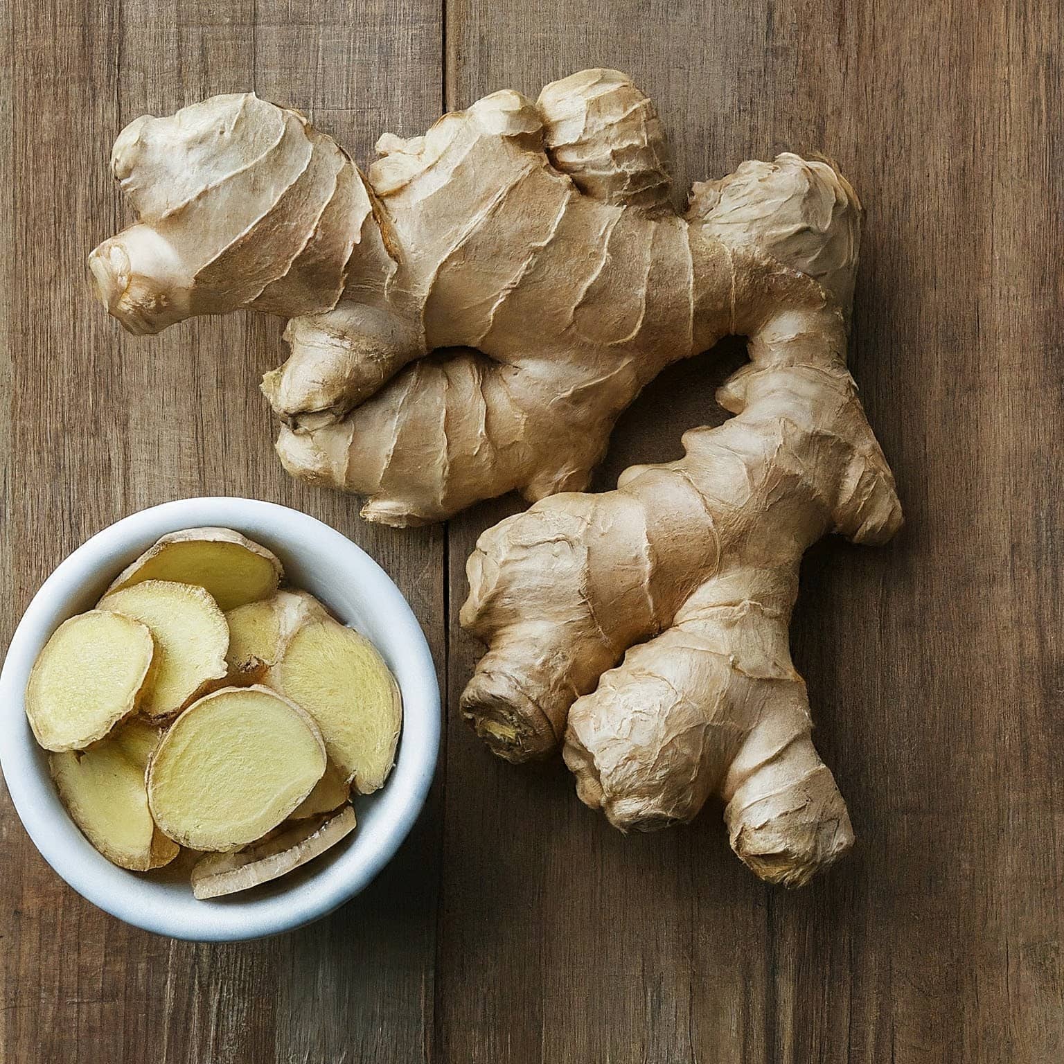 Fresh and dried ginger roots on a rustic table